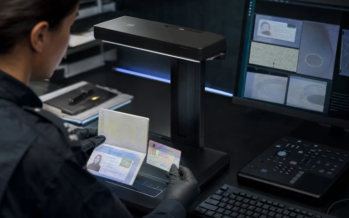Analyst inspecting a passport and identity card at a forensic document workstation